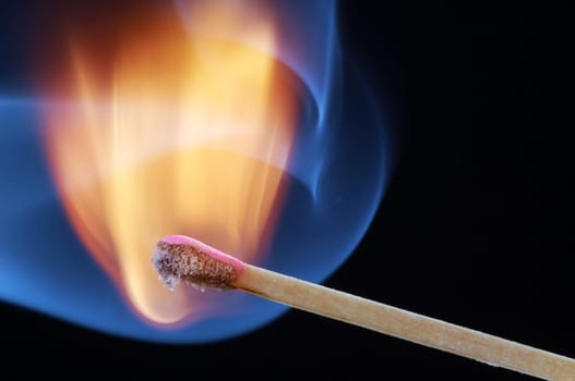 Match that has just been lit against a black background