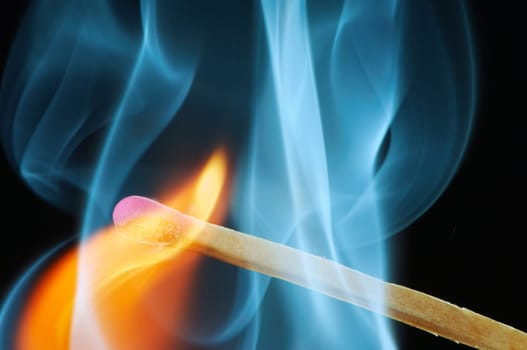 Match that has just been lit against a black background