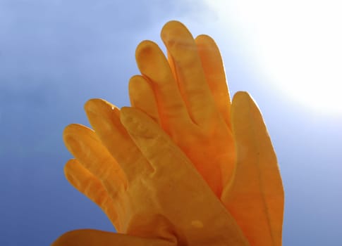 Yellow gloves against the sky