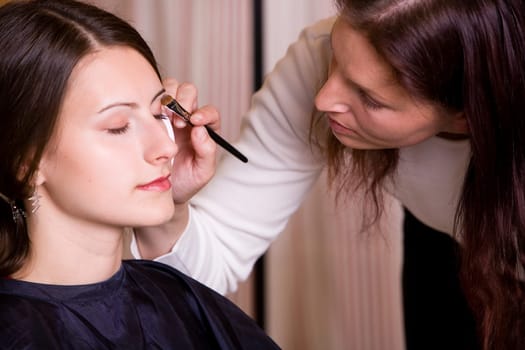 Woman doing make-up by make-up artist II