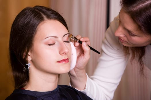 Woman during make-up by make-up artist III
