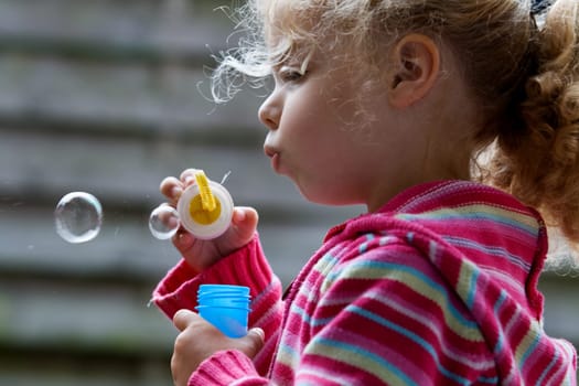 Girl makes soap bubbles