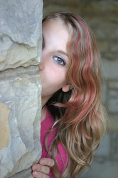Young woman peeking around the corner