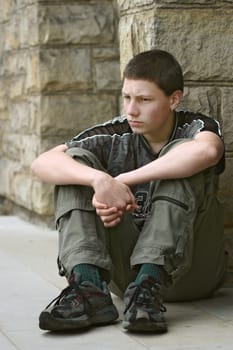 Teenage boy sitting on a wall