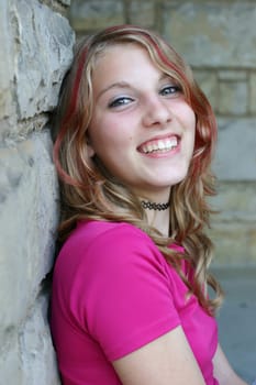 Young woman leaning against a wall