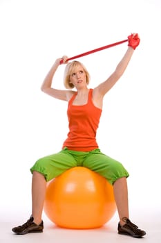 Young woman on exercise ball with ribbon