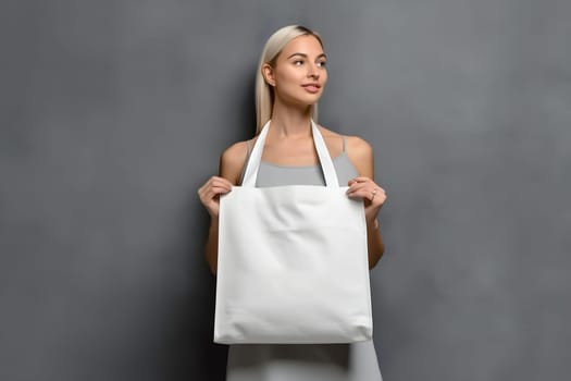 caucasian woman holding blank white tote bag made of canvas fabric with handle her neck, mock up design. Neural network generated in May 2023. Not based on any actual person, scene or pattern.