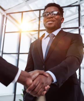 Shot of a young businessman shaking hands with a colleague in the office