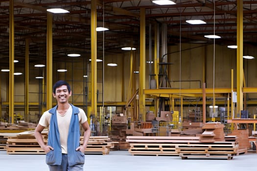 smiling asian male worker standing in a warehouse. Neural network generated in May 2023. Not based on any actual person, scene or pattern.