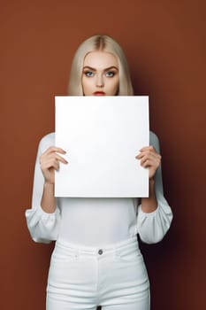 caucasian woman holding a blank sheet of paper on brown background. Neural network generated in May 2023. Not based on any actual person, scene or pattern.