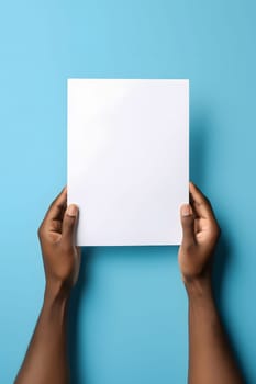 african american hands holding blank sheet of paper on blue background. Neural network generated in May 2023. Not based on any actual person, scene or pattern.