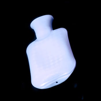 Blue hot water bottle in front of black