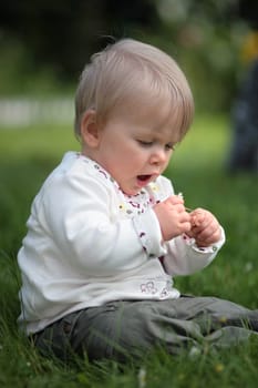 Baby looks at a flower in amazement