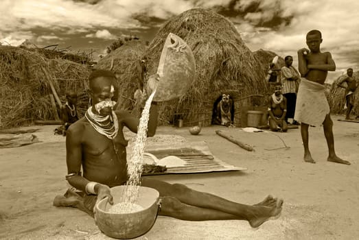 Karo village in southern Ethiopia Woman separating the grain from the chaff.