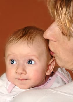 Mother tenderly kisses her baby