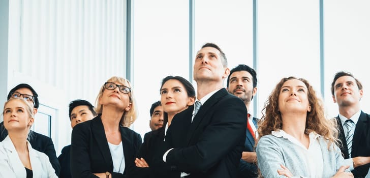 Successful business people standing together showing strong relationship of worker community. A team of businessman and businesswoman expressing a strong group teamwork at the modern office. Jivy