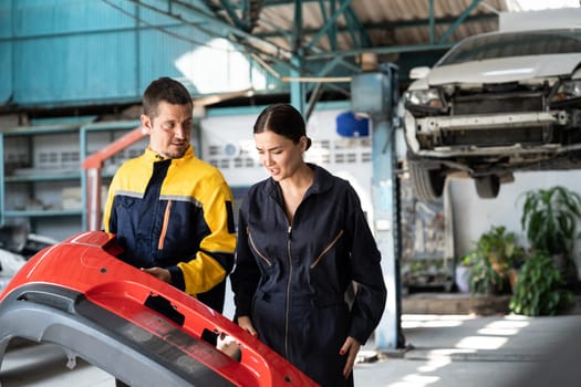 Two happy vehicle mechanic celebrate and high five after made successful car inspection or repair in automotive service car workshop. Technician team enjoy accomplishment together in garage. Oxus