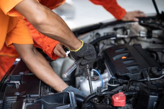 Automotive service mechanic inspect and diagnose car engine issue, repairing and fixing problem in garage workshop. Technician car care maintenance working on internal components of vehicle. Oxus