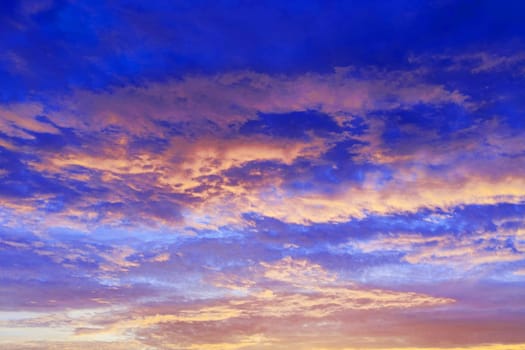 dark blue sunset sky with pink backlit clouds for a dramatic sky background.