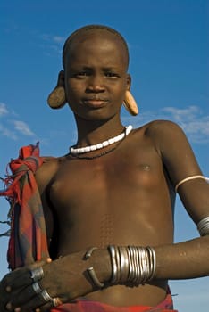 Pretty girl of the Mursi tribe in the Omo Valley,south. Ethiopia. So far,she has been spared from the "lip beautification""."