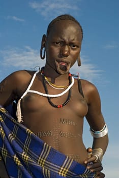A Mursi girl without the lip plate. Not a particularly aesthetic sight. The plates are usually only served outside the house (eigtl. Cottage :) ) carried. Especially unmarried women and girls flaunt the plates to attract attention.