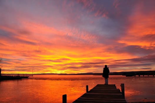 Teenager on the jetty at sunset