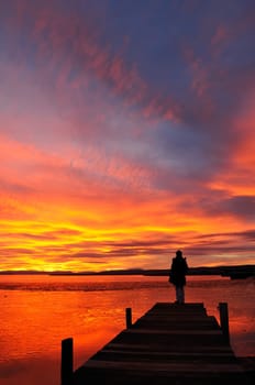 Child on jetty at sunset