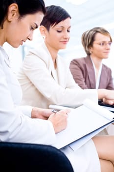 Businesswomen writing notes on training