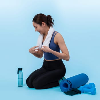 Athletic and sporty asian woman resting after intensive cardio workout training. Healthy exercising and fit body care lifestyle pursuit in studio shot isolated background. Vigorous