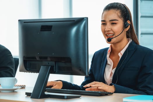 Business people wearing headset working in office to support remote customer or colleague. Call center, telemarketing, customer support agent provide service on telephone video conference call. Jivy