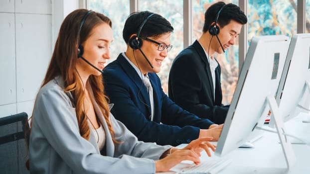 Business people wearing headset working in office to support remote customer or colleague. Call center, telemarketing, customer support agent provide service on telephone video conference call. Jivy