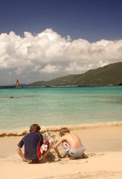 boys building a sand castle at the beach