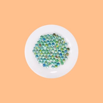 Plate of marbles in front of orange