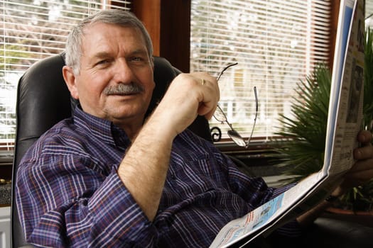 Pensioner reads a newspaper