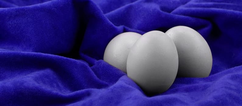 Three eggs on blue velvet