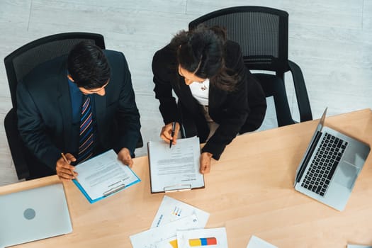 Business people group meeting shot from top view in office . Profession businesswomen, businessmen and office workers working in team conference with project planning document on meeting table . Jivy