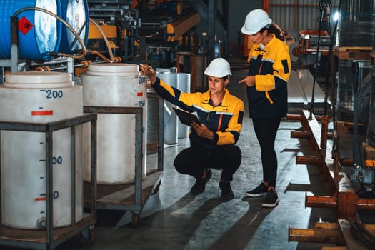 Two factory workers or engineers conduct professional inspection on machine or procedure in chemical plant, chemistry factory workplace and industrial profession concept. Exemplifying