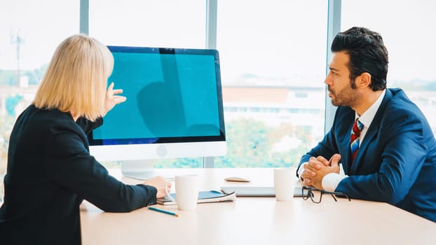 Business people in the conference room with green screen chroma key TV or computer on the office table. Diverse group of businessman and businesswoman in meeting on video conference call . Jivy