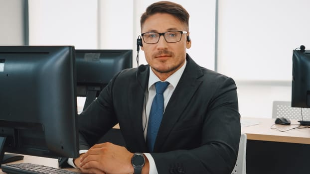 Business people wearing headset working in office to support remote customer or colleague. Call center, telemarketing, customer support agent provide service on telephone video conference call. Jivy