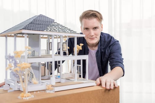 Architect designer reviewing house frame model with no wall, brainstorming interior design and improvement idea with actual home scale. Professional and creativity in architectural design. Iteration