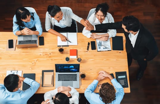 Top view happy businesspeople in high five gesture and successful efficient teamwork. Diverse race office worker celebrate after made progress on marketing planning in corporate office. Meticulous