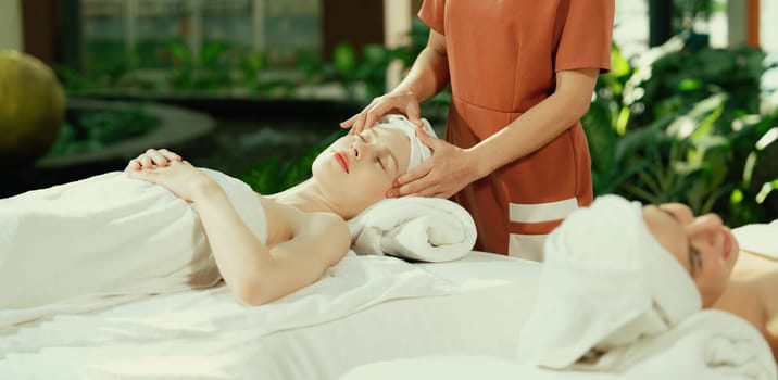 A portrait of two caucasian woman with beautiful skin having facial massage while falling the deep state of relaxation surrounded by outdoor natural and peaceful environment. Tranquility.