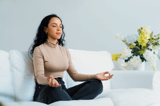 Young African American woman practice crucial mindful meditation at home living room for improving mental health strength and peaceful beautiful living