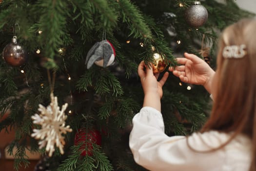 Girl decorates a tree for Christmas