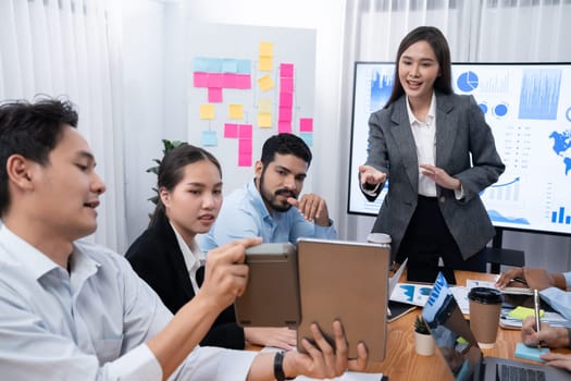 Young asian businesswoman presenting data analysis dashboard on TV screen in modern meeting. Business presentation with group of business people in conference room. Concord