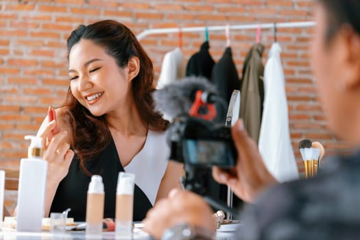 Woman influencer shoot live streaming vlog video review makeup uttermost social media or blog. Happy young girl with cosmetics studio lighting for marketing recording session broadcasting online.