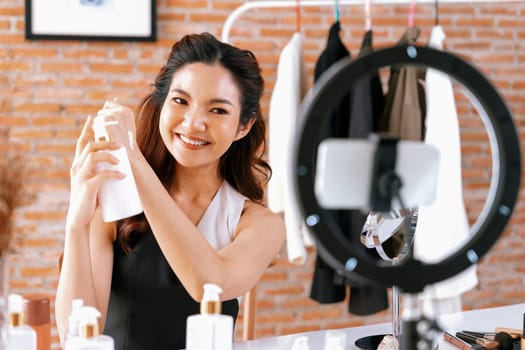 Woman influencer shoot live streaming vlog video review makeup uttermost social media or blog. Happy young girl with cosmetics studio lighting for marketing recording session broadcasting online.