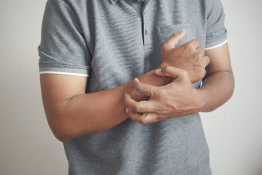 man suffering from itching skin, close up