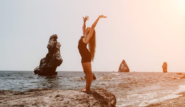 Woman travel sea. Young Happy woman in a long red dress posing on a beach near the sea on background of volcanic rocks, like in Iceland, sharing travel adventure journey