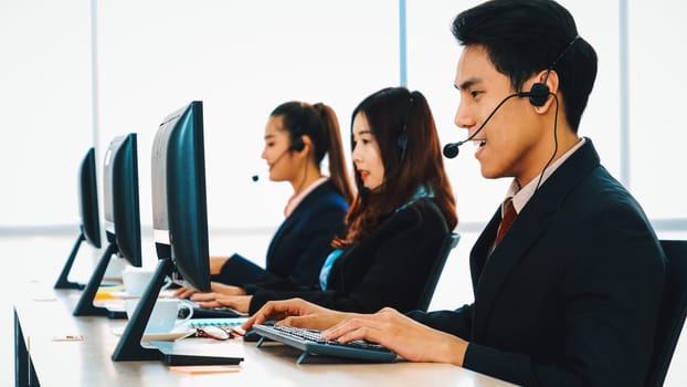 Business people wearing headset working in office to support remote customer or colleague. Call center, telemarketing, customer support agent provide service on telephone video conference call. Jivy